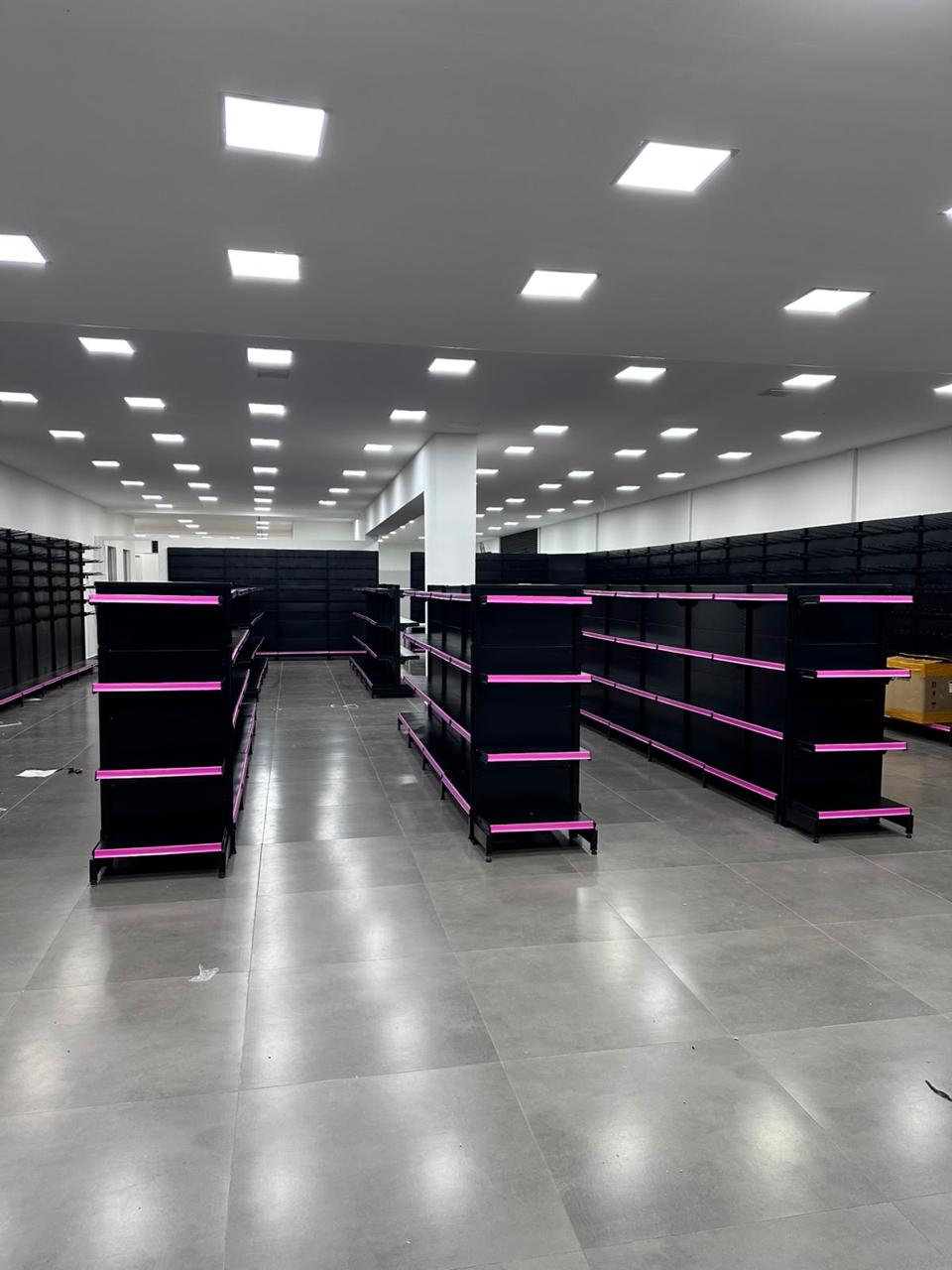 Gôndolas pretas com detalhes rosa em loja